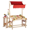 Magasin en bois enfant avec auvent rouge garni de marchandise jouet.